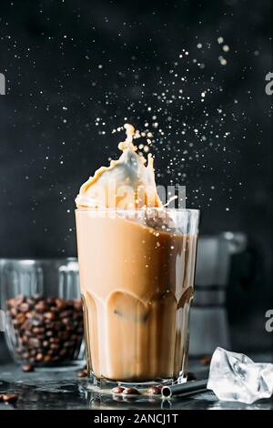 https://l450v.alamy.com/450v/2ancj1t/splash-of-iced-coffee-in-tall-glass-and-coffee-beans-2ancj1t.jpg