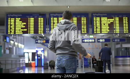 Tourist looking at time table, checking schedule on screen in bus terminal Stock Photo