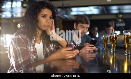 Disappointed people monitoring online bets in phones, losing money in gambling Stock Photo
