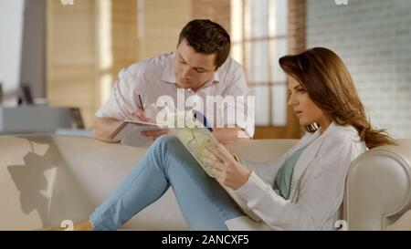 Happy young couple planning weekend trip together, choosing destination on map Stock Photo