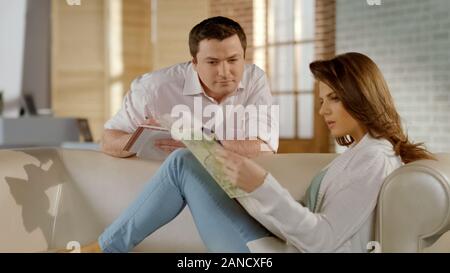 Happy young family planning weekend trip together, choosing destination on map Stock Photo