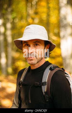 Close-up portrait of tourist man in panama hat. Colorful bokeh Stock Photo