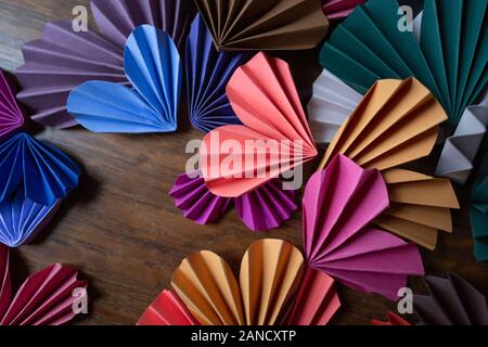 Multi-colored paper hearts on wood surface for Valentine's Day Stock Photo