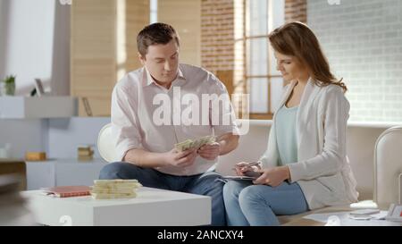 Young family counting big sum of money, initial investment for family business Stock Photo
