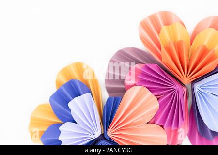 Multi-colored paper origami hearts arranged to make flower design Stock Photo