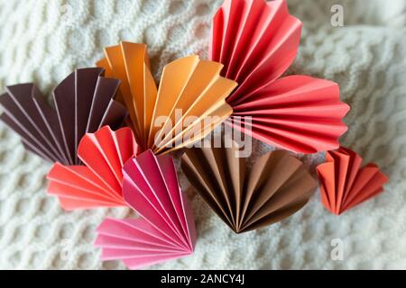 Multi-colored origami paper hearts against knitted background Stock Photo