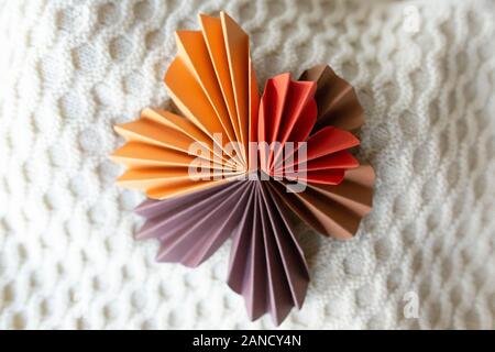 Folded paper hearts arranged into geometric design on knitted fabric Stock Photo