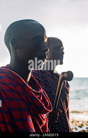 Two masai men in traditional clothes standing in front of sea Stock Photo