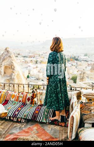 Woman at sunrise with hot air balloons rising up in Cappadocia Turkey Stock Photo