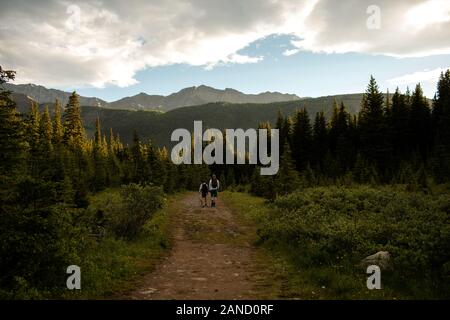Father and son hike after day of fly fishing in Rocky Mountains Stock Photo