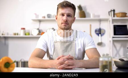 Handsome young chef looking at camera, ad of culinary courses, nutrition tips Stock Photo