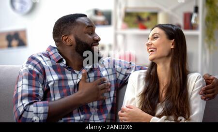 Laughing mixed-race couple joking, having funny conversation, togetherness Stock Photo