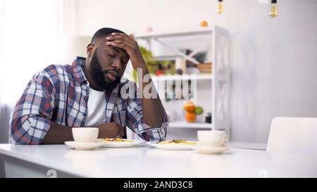 Tired African-American man having headache after hard day, feeling exhausted Stock Photo