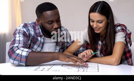 Young mixed-race couple planning interior design of new house, relationship Stock Photo