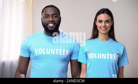 Smiling multiethnic volunteers standing straight in rehabilitation center, help Stock Photo
