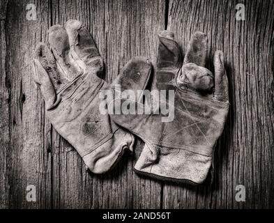 Black & white studio still life close-up of worn leather work gloves Stock Photo