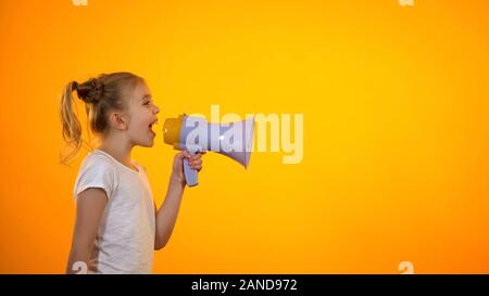 Schoolgirl shouting in megaphone, making announcement, sales and discounts Stock Photo