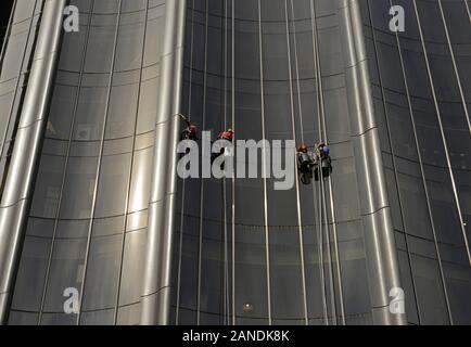 Window cleaners work on the Chaoyang Park Plaza office building complex, which was designed by MAD architects in the classic water and mountains style Stock Photo