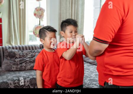 Asian chinese father give ang pao to her sons Stock Photo