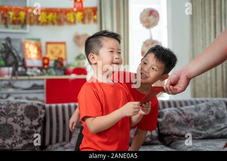 Asian father give ang pao to her son Stock Photo