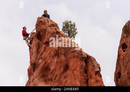 Two rock climbers set up a belay station after getting to the top of a rock in Garden of the Gods in  Colorado Springs. Stock Photo