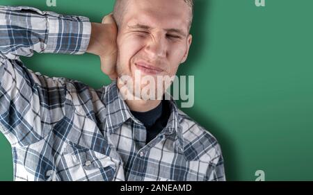 stop that noise! the male feels bad and closes his ear with his hand Stock Photo