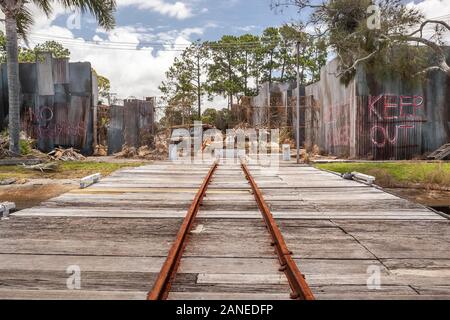 Gold Coast, Australia-Nov 22,2010: a small rusty private railway on wooden ground, in Wrecking yard or junkyard, rusty car and truck near a metal and Stock Photo