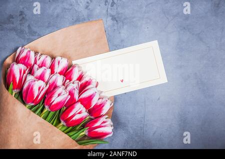 Bouquet of red tulips for a holiday women's day and valentine's day against a gray textured wall Stock Photo