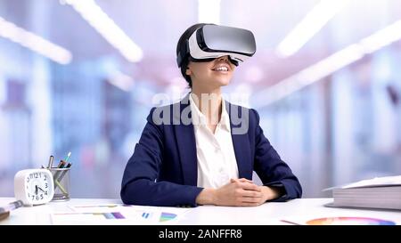 Happy business woman in vr goggles sitting office desk, cyber networking, future Stock Photo