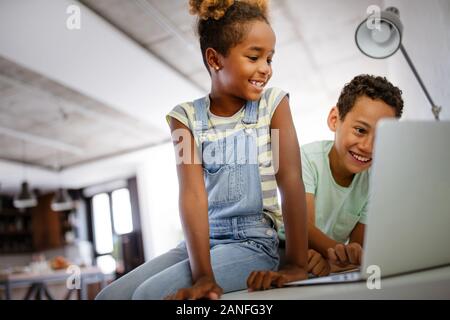 Game, study, fun concept. Happy children spending time with notebook and modern technology. Stock Photo