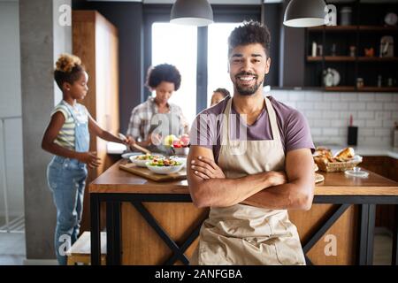 Happy family in the kitchen having fun and cooking together. Healthy food at home. Stock Photo