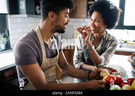 Beautiful young couple cooking healthy food together at home. Having fun in the kitchen. Stock Photo