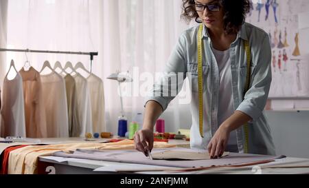 Professional designer transferring pattern samples to fabric, clothes making Stock Photo