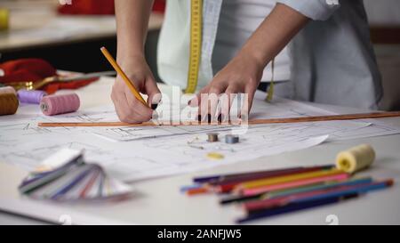 Designer drawing template for sewing new dress according to her sketches Stock Photo