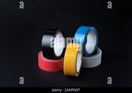 Set of multi colored rolled adhesive tape at black background. Stock Photo