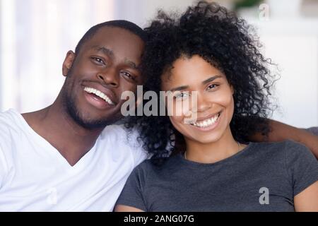 Portrait of happy black couple hugging relaxing at home Stock Photo
