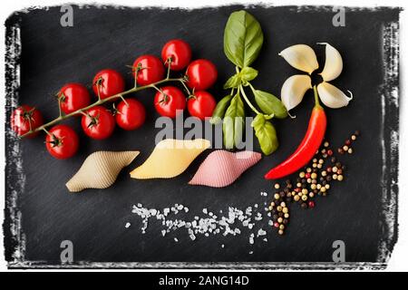 Pasta with vegetables ingredients on a black stone for an Italian pasta dish Stock Photo
