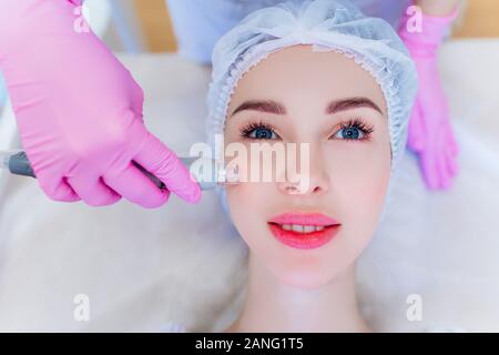 Hardware skin care. A young girl cares for her face. Beauty treatment. Procedures. Advertising. Stock Photo