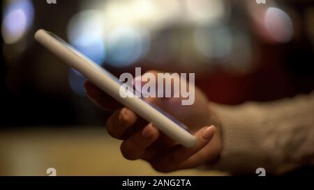 Young woman scrolling smartphone, sitting in cafe and relaxing, coffeebreak Stock Photo