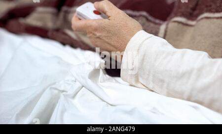 Patient pushing button to relieve agony, calling nurse for help, feeling unwell Stock Photo