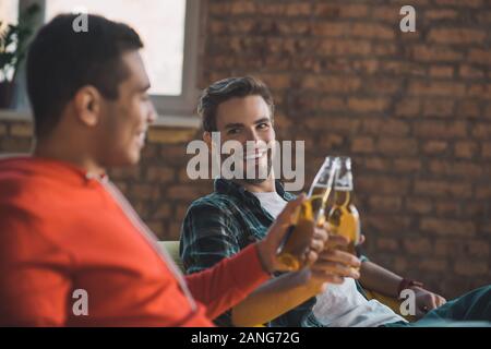 Delighted joyful men cheering with their drinks Stock Photo