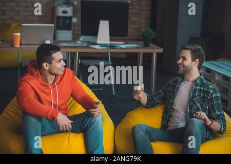 Joyful nice men enjoying their pleasant conversation Stock Photo