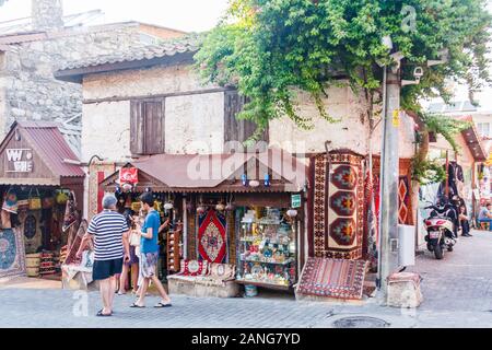 Side, Turkey - September 9th 2011: Tourists walking past a shop selling souvenirs and carpets. The town is a popular tourist destination.