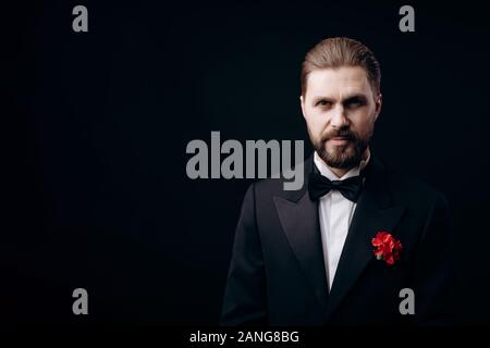 Handsome Brunet in Black Tie With a Carnation Boutonniere Stock Photo