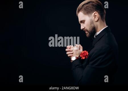 Bearded Man in Dinner Suit Rubbing His Hands in Pray Stock Photo
