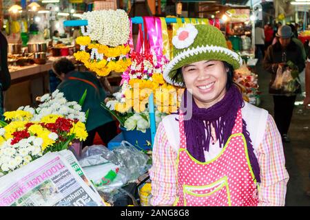 Nan, Thailand - December 16th 2014: Smiling flower stall vendor on the market. A market is held every day in the town centre. Stock Photo