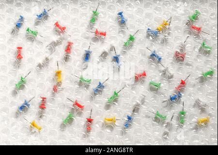 Abstract Bubble Wrap and Colored Thumbtacks Stock Photo