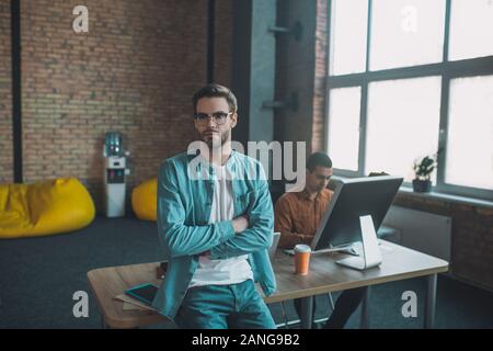 Intelligent bearded man sitting on his desk Stock Photo