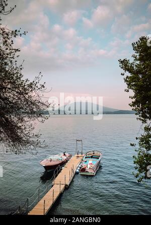 Two moored classic vintage speedboats on a private jetty in the Italian Lakes - Lake Maggiore, Piedmont, Italy EU. Stock Photo