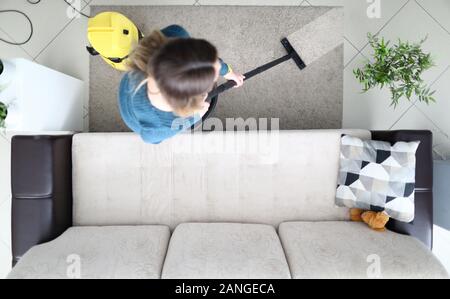 Woman cleaning carpet with vacuum cleaner at home Stock Photo